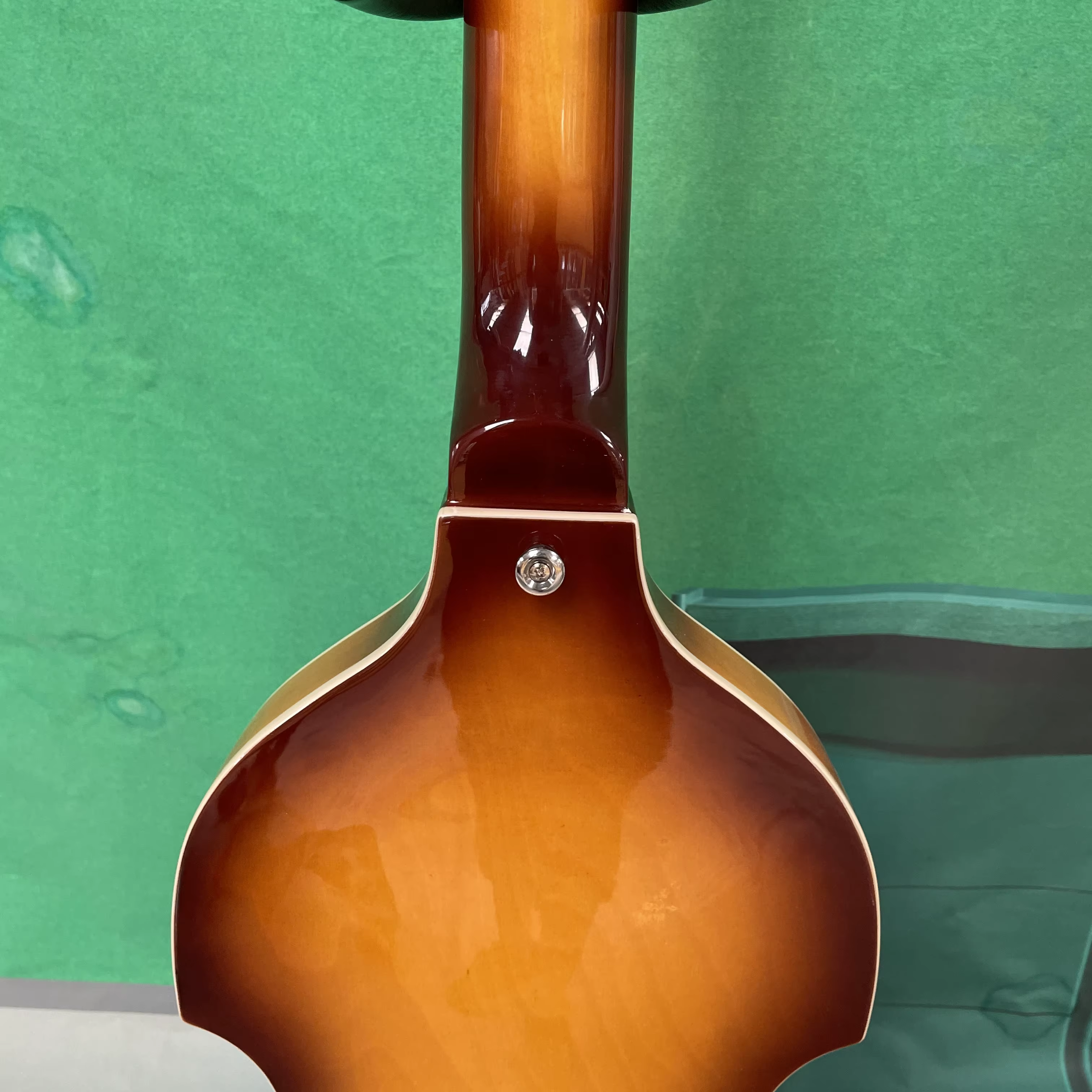 Guitare basse électrique à 4 cordes, corps de style violon, pickguard blanc, quincaillerie argentée, idéale pour les guitaristes débutants.